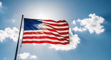 Obraz premium American flag waving in the wind against a blue sky