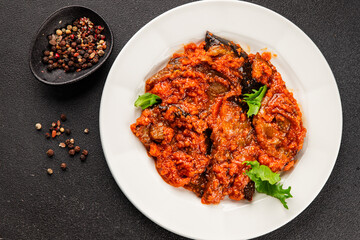 Fototapeta premium Eggplant vegetable sauce tomato, carrot, onion, chopped vegetables ajapsandali tasty snack fresh delicious gourmet food background on the table rustic food,top view copy space keto and paleo diet 