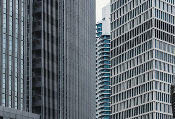Fototapeta premium Moderne Hochhausfassaden mit vertikalen Linien und geometrischen Mustern in städtischer Architektur