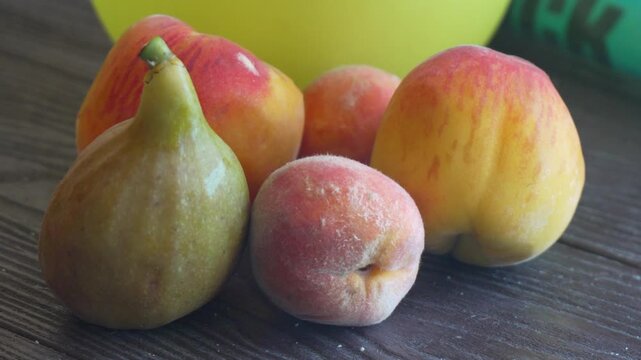 Figs Peaches Apples Wooden Table - Freshly picked figs, peaches, and apples on a wooden table.