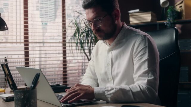 Busy Caucasian business man working laptop inside office serious male developer typing on computer focused manager executive startup employee broker corporate businessman online occupation agency work