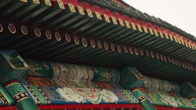 Ornate Chinese temple roof eaves showcase richly painted brackets, carved beams, gilded motifs and colorful patterns under dramatic angled perspective, closeup study of traditional timber