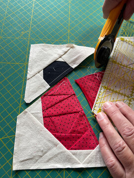 Close-up of Foundation Paper Piecing Quilting with Cotton Fabric and rotary cutter in progress 