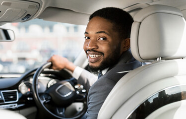 Smiling African Car Driver Man Looking At Camera Posing Sitting In New Auto. Selective Focus