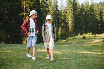 Fototapeta premium Young explorers hiking in forest, embracing nature's wonders