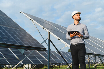 Naklejka premium Engineer inspecting solar panels, managing renewable energy production