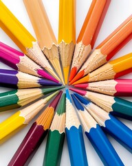 Fototapeta premium Collection of colored pencils arranged in a radial fan, sharpened tips visible, isolated on white background 