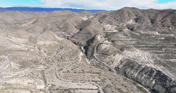 Aerial cinematic view of Tabernas Desert badlands landscape in Almeria Spain dry arid terrain and eroded hills