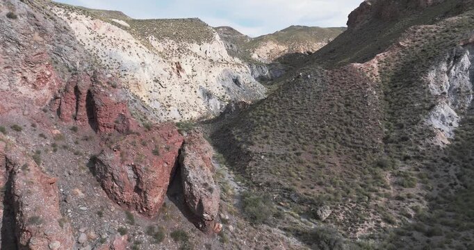 Aerial pass over steep desert ravine and eroded slopes Tabernas Spain dry cinematic landscape