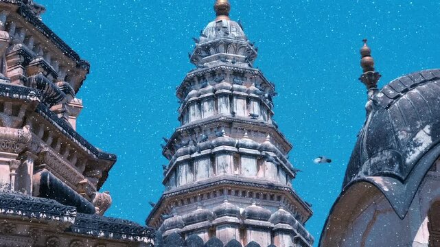 A large flock of pigeons fly over Old Rangji Temple and sit on its dome, in the city of Pushkar, India, one of the sacred pilgrimage sites in Hinduism. View through sparkling particles. Slow mo, slo m