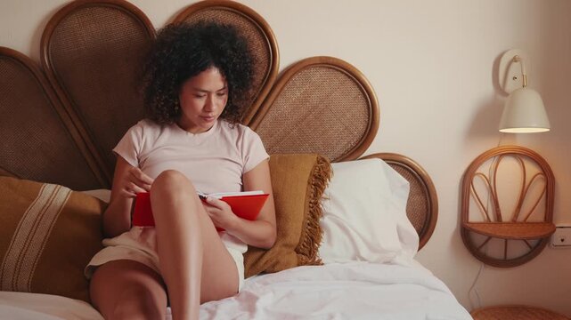 Young Woman Journaling Thoughtfully in Her Cozy Bedroom