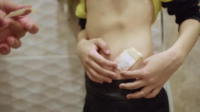 Applying adhesive plaster to child abdominal wound close up