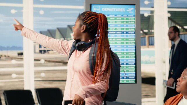 Agitated teenager daughter eager to leave on holiday with parents, fidgeting and being impatient about boarding the plane. Young black child with backpack excited and nervous, youth innocence.