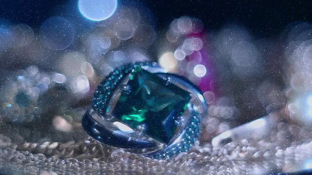 Beautiful shiny, sparkling golden jewelry on a glass surface with bright flares is rotation. View through sparkling particles. Macro. Closeup. Shallow depth of field