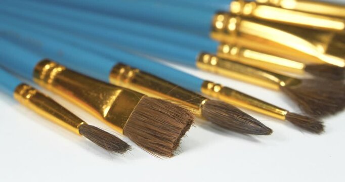 Brush set of various shapes for painting. Horse hair brushes in various sizes and shapes. Painting brushes with natural pony bristle. Round and flat brushes for artistic painting lie on white canvas