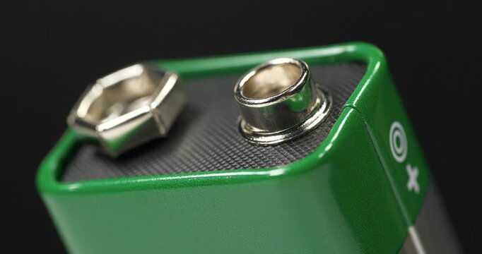 Nine-volt battery with visible terminals, ready to power small electronic devices
