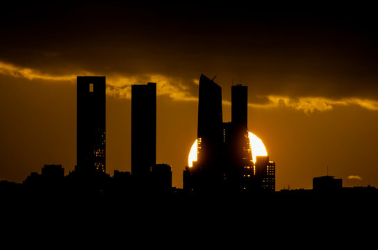 Sunset behind the four towers of the Castellana in Madrid