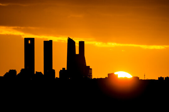 Sunset behind the four towers of the Castellana in Madrid