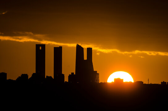 Sunset behind the four towers of the Castellana in Madrid