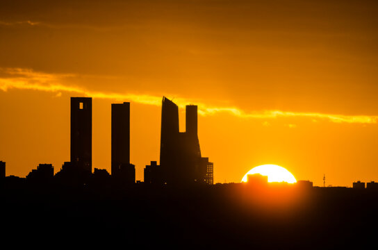 Sunset behind the four towers of the Castellana in Madrid