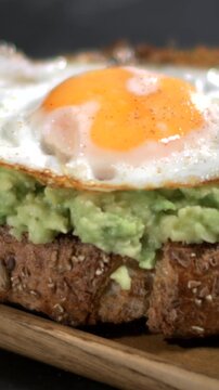 Super slow motion, Indepth Review Of Radiant Egg Yolk Accompanied By Silky Avocado Spread Over Bread Slices