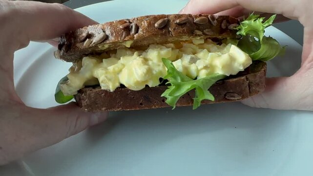 Eating an Egg Salad Sandwich with Wheat Bread