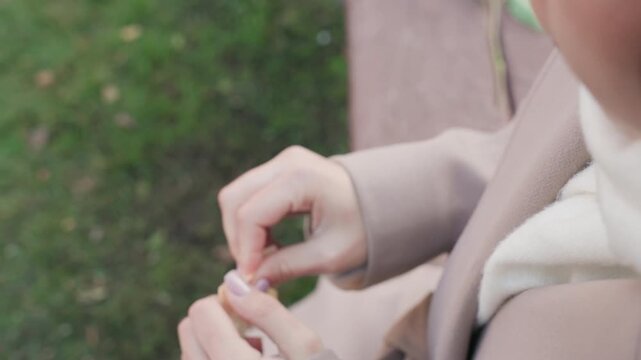 White woman tearing small handwritten note, red rose left on bench, decisive fingers and distant profile, park path and cool breeze, contemplative closure suggesting teacher, traveler, friend