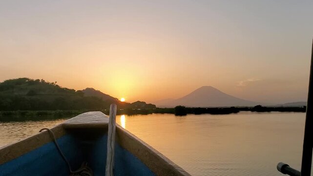 View of a sunset at water level from a moving boat.