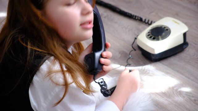Teenager girl with a vintage rotary phone, ready to make a call. Pretty teenager girl talking to someone on the phone.