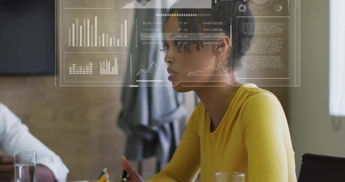 Woman in yellow top leading business meeting, pointing pen and animating HUD charts to show data