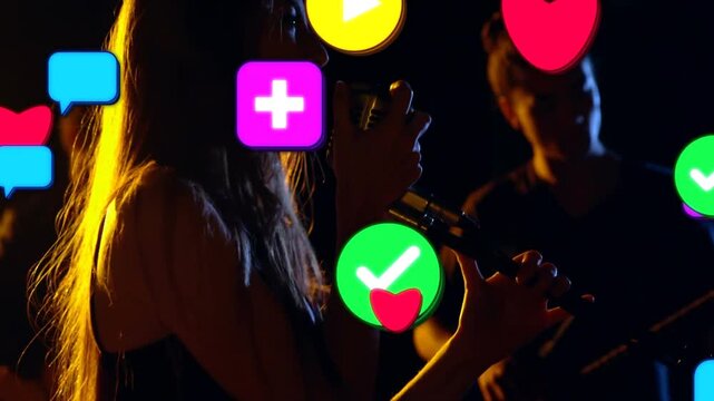 Singer moving to mic, singing on music stage, causing icons to swell across frame for fans