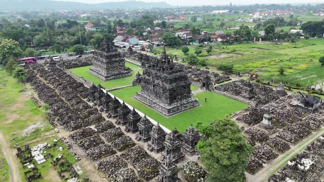 Low altitude drone tracking shot from left to right behind Candi Plaosan Lor, Indonesia