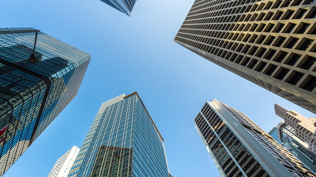 Low angle view of modern skyscrapers against clear blue sky in financial district, showcasing urban architecture, business growth, corporate environment and future city development concept