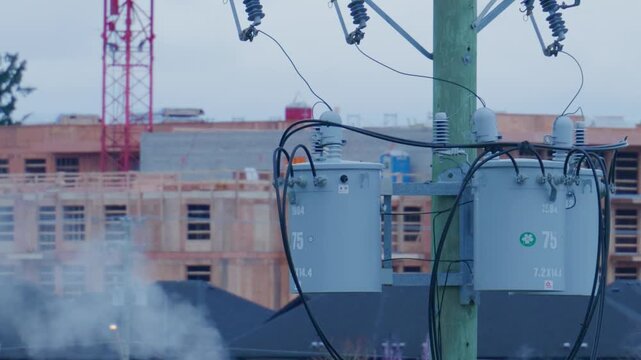 Langford, BC, Canada &ndash; March 29, 2026: Utility pole transformers near new housing construction