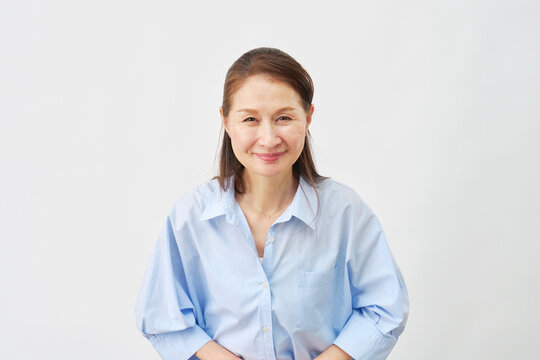 白背景でお辞儀する高齢女性　カメラ目線