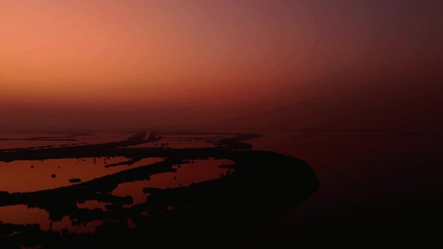 Aerial shot of an intense and colourfull sunrise over Baqar Lake.