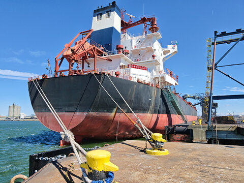 Cargo ship moored at Norfolk Terminal DTA with mooring lines and industrial port infrastructure