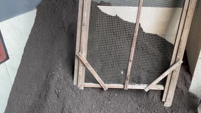 Handmade Wooden Sieve on Dark Soil Pile