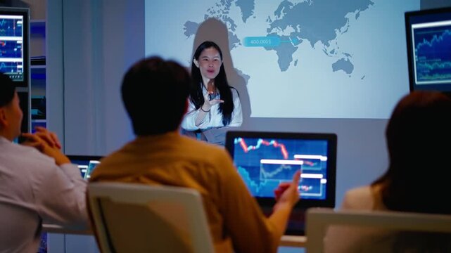 Asian businesswoman or speaker presenting a strategic marketing vision on a global shipping route map.Showing logistics infographics,statistics and product distribution on screen during a conference.