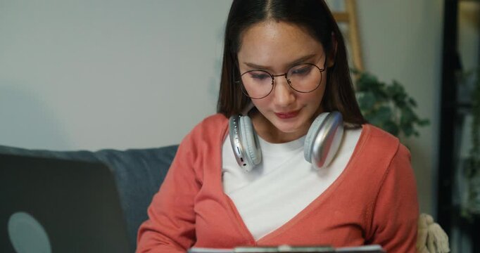 An Asian accountant inspects investment costs and earning potential, analyzing strategies on her computer despite late-night stress.