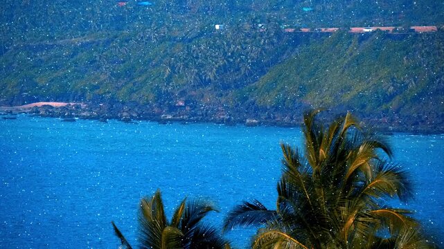 Amazing place, wild deserted beach, at the edges of which the waves break on volcanic stones, the dream of any tourist, Goa, India. View through sparkling particles