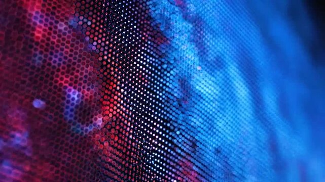 Close-up view of a digital screen displaying a vibrant abstract pattern of red and blue illuminated dots