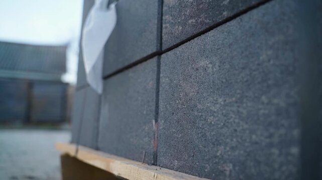 Smooth camera tracking along construction materials on wooden pallet close-up concrete elements