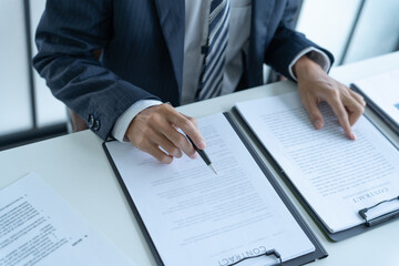 Lawyer in suit checking contract  document on table