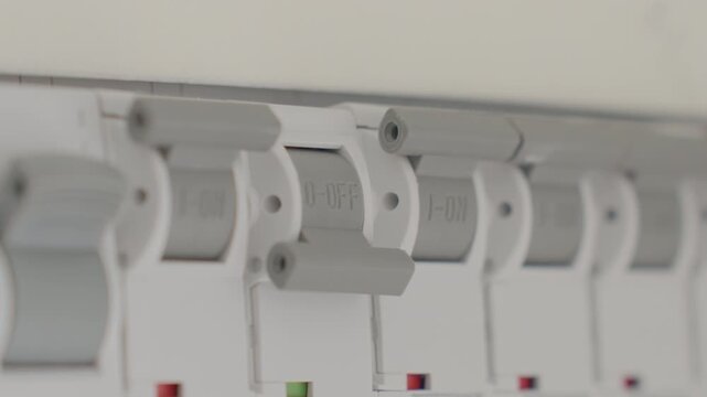 Hand switching circuit breaker in electrical distribution panel. Concept of power control electrical safety household utility and energy management.