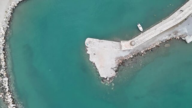 Beautiful turquoise sea water surrounding the breakwater and harbor of rethymno city in crete