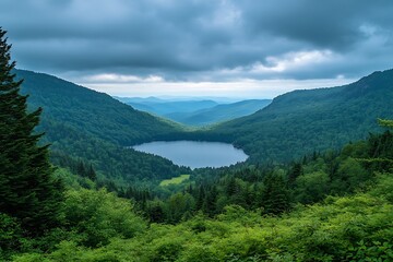 Fototapeta premium Dramatic deep blue lake surrounded by towering green mountain forests