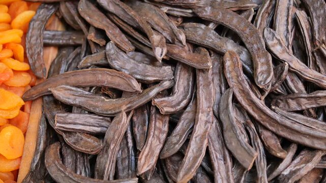 Collecting carob pods in a local market in autumn