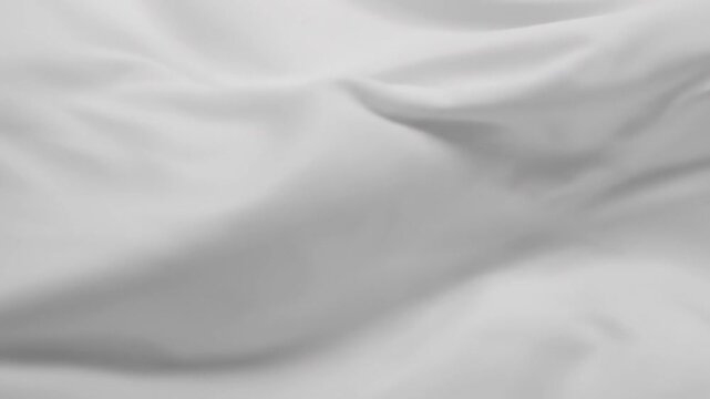 A close-up view of a rumpled white fabric with soft folds and creases.