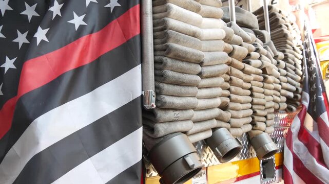 Red thin line black american flag on firefighter truck. Hose of firetruck and fire fighters symbol in New York, United States. 911 remembrance, fire department engine vehicle. September 11 Patriot Day